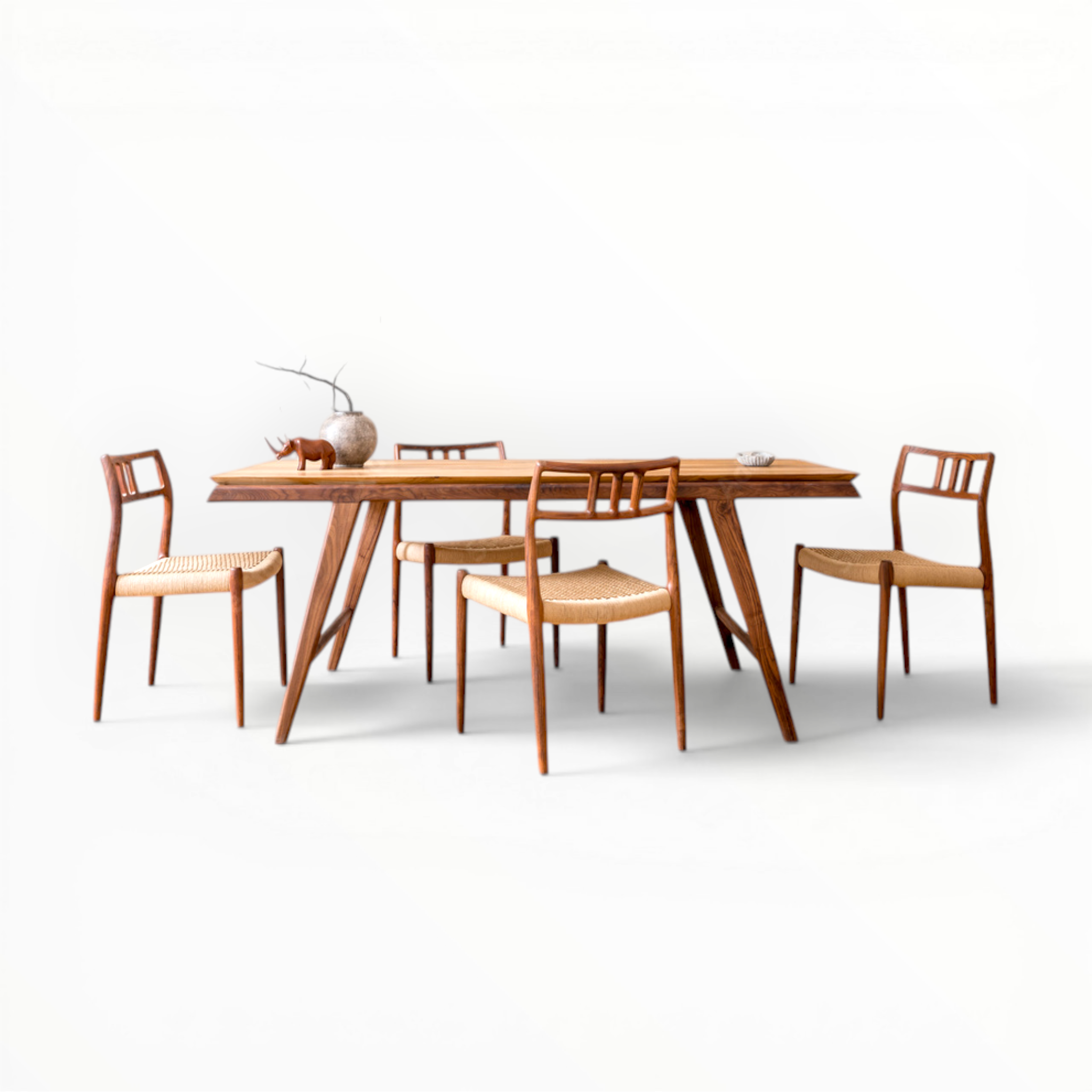 Wooden dining table with four chairs on a white background