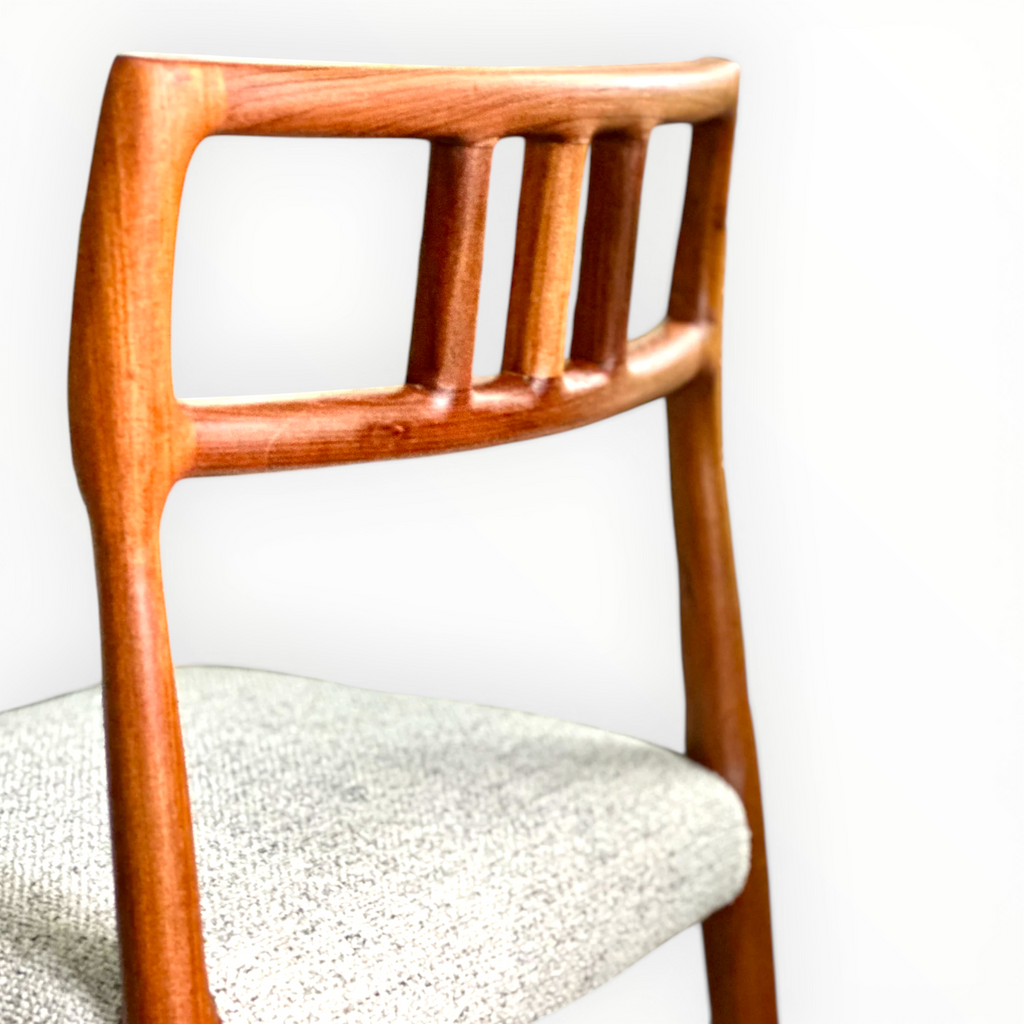 Wooden chair with a white cushioned seat against a light background