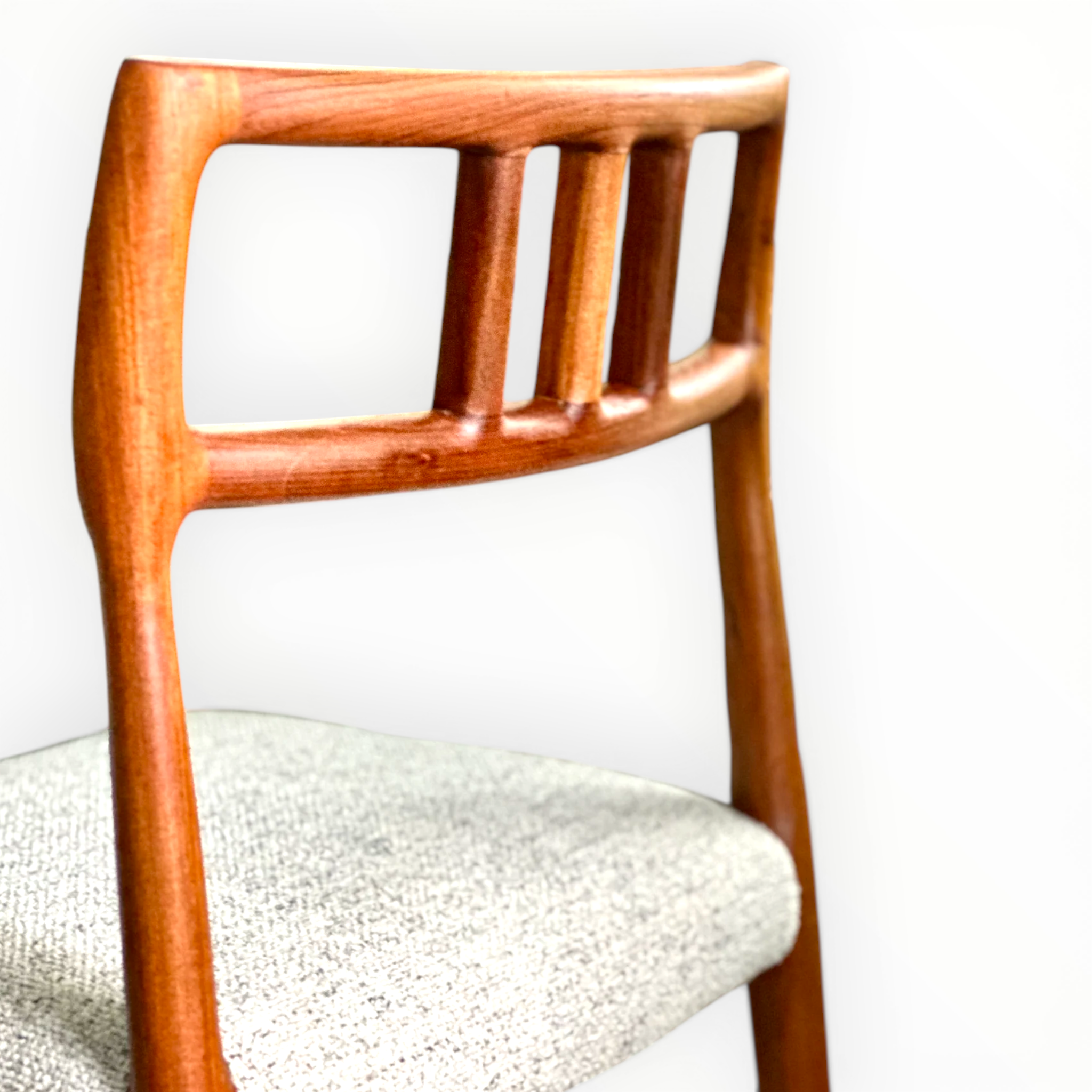 Wooden chair with a white cushioned seat against a light background