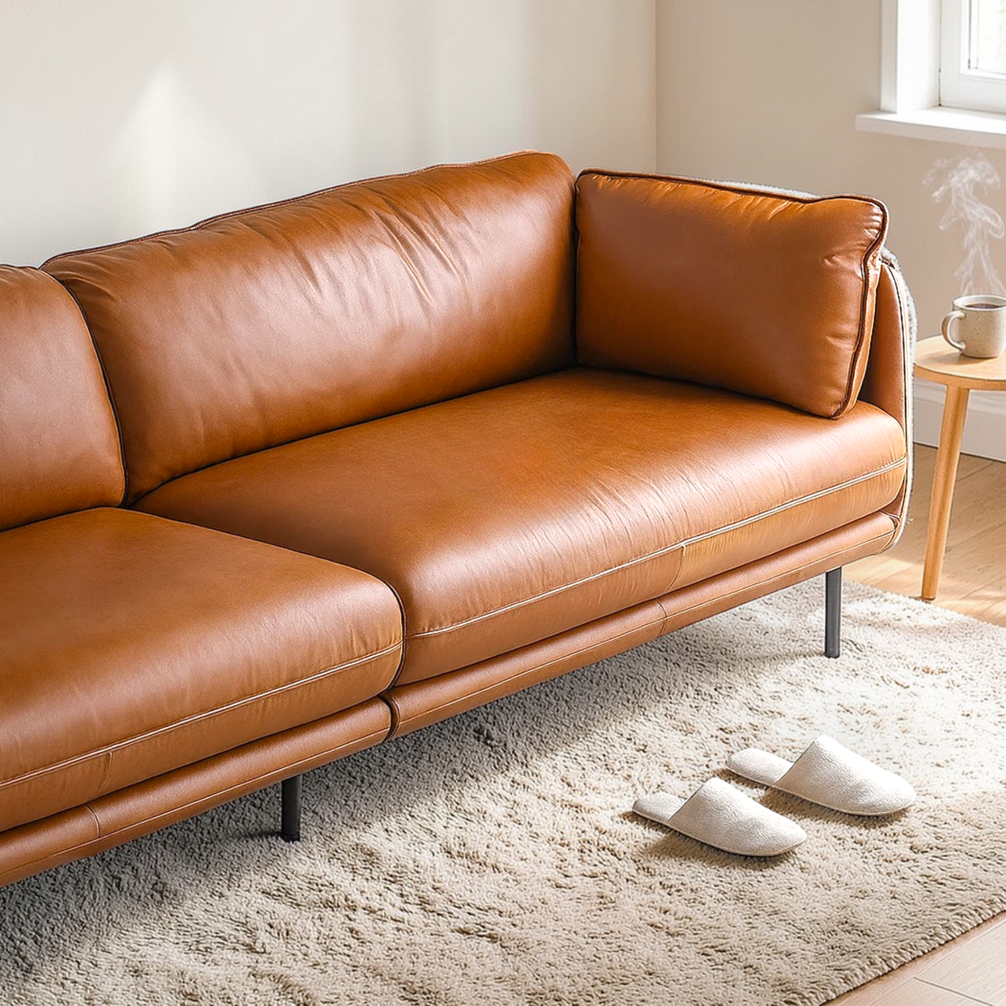 Brown leather sofa in a living room with a rug and slippers.