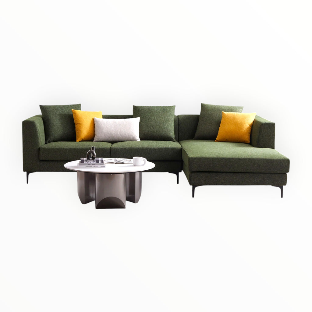 Green sectional sofa with yellow and white cushions on a white background