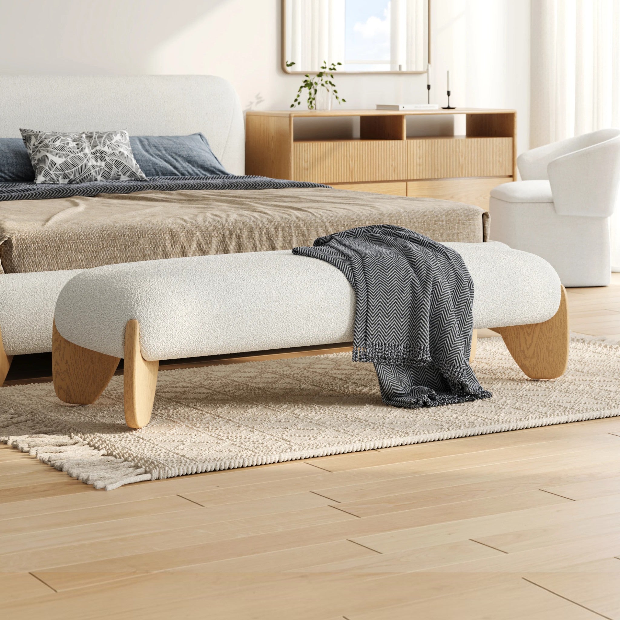 Modern living room with a bench, ottoman, and decorative pillows.
