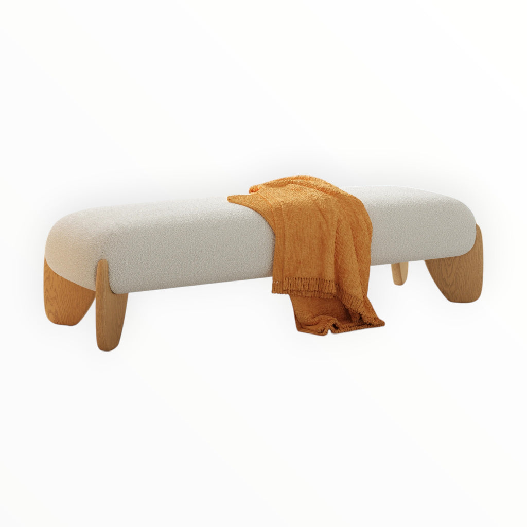 White bench with wooden legs and a mustard yellow blanket draped over it on a white background