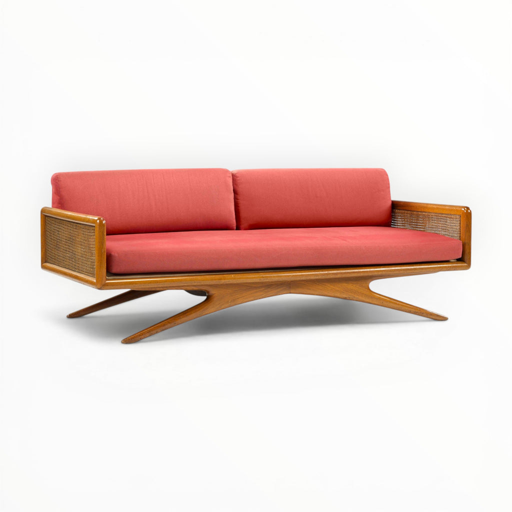 Sofa with red cushions and wooden frame on a white background