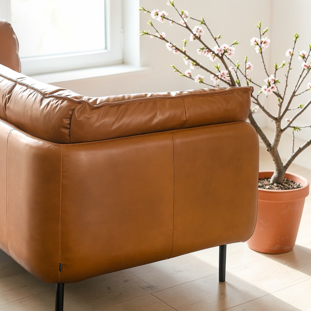 Brown leather armchair in a room with a potted plant