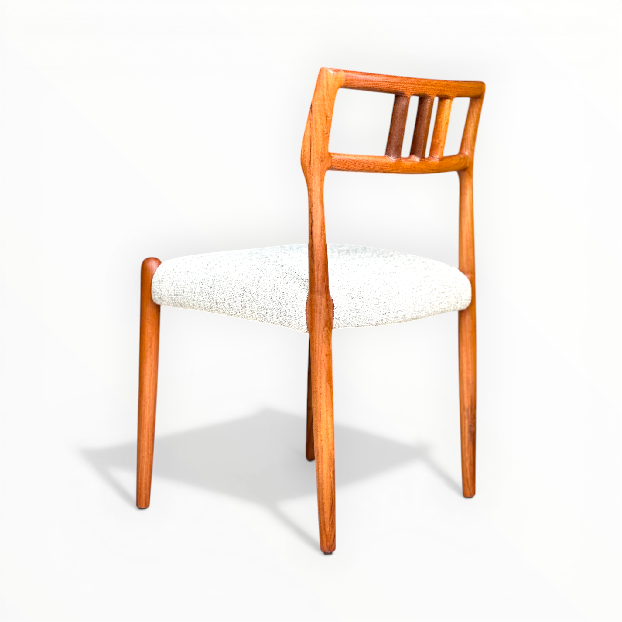 Wooden chair with a white cushion on a white background
