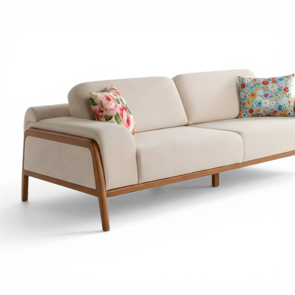 Beige sofa with wooden frame and floral cushions on a white background