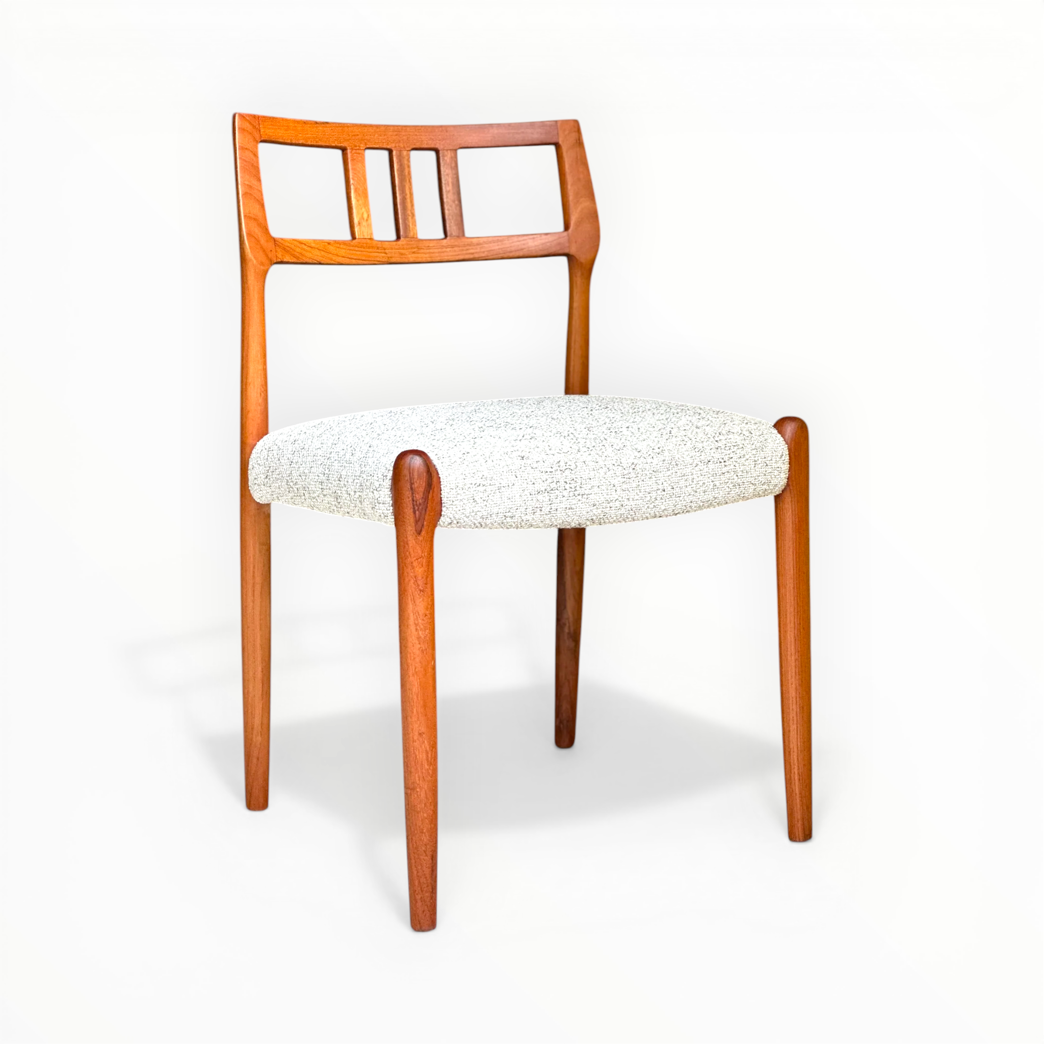 Wooden chair with a white cushioned seat on a white background