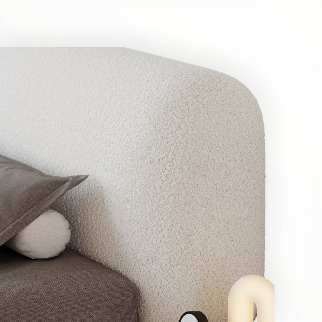 Close-up of a textured gray sofa with a pillow and round cushion on a white background