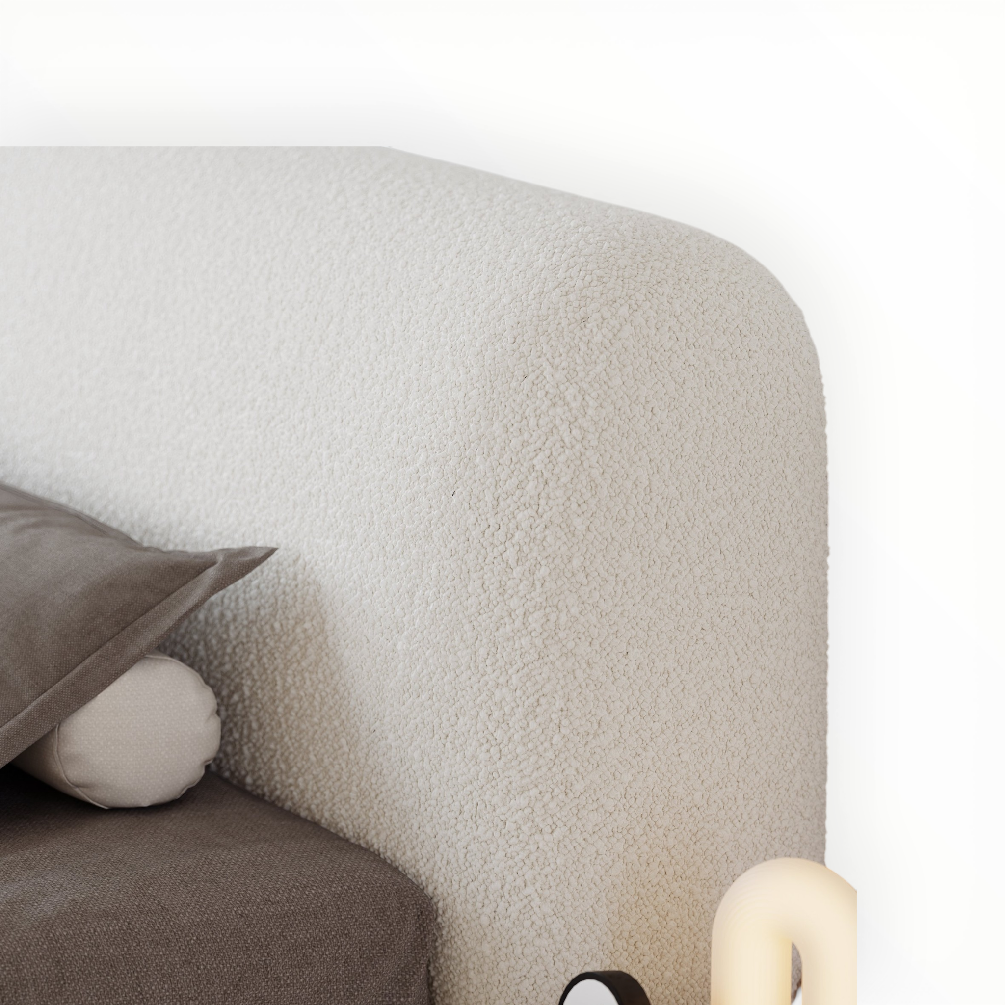 Close-up of a textured gray sofa with a pillow and round cushion on a white background