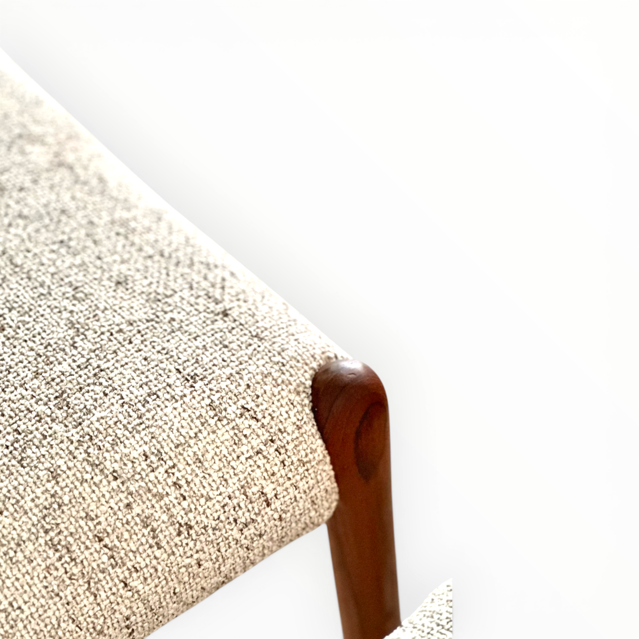 Close-up of a textured fabric surface with a wooden edge on a white background