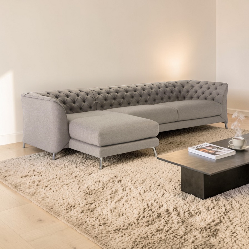 Gray sectional sofa in a living room with a coffee table and rug.