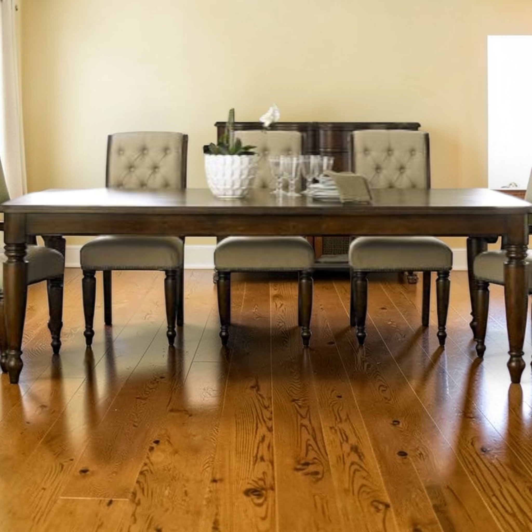 Dining room with wooden table and chairs on a wooden floor.
