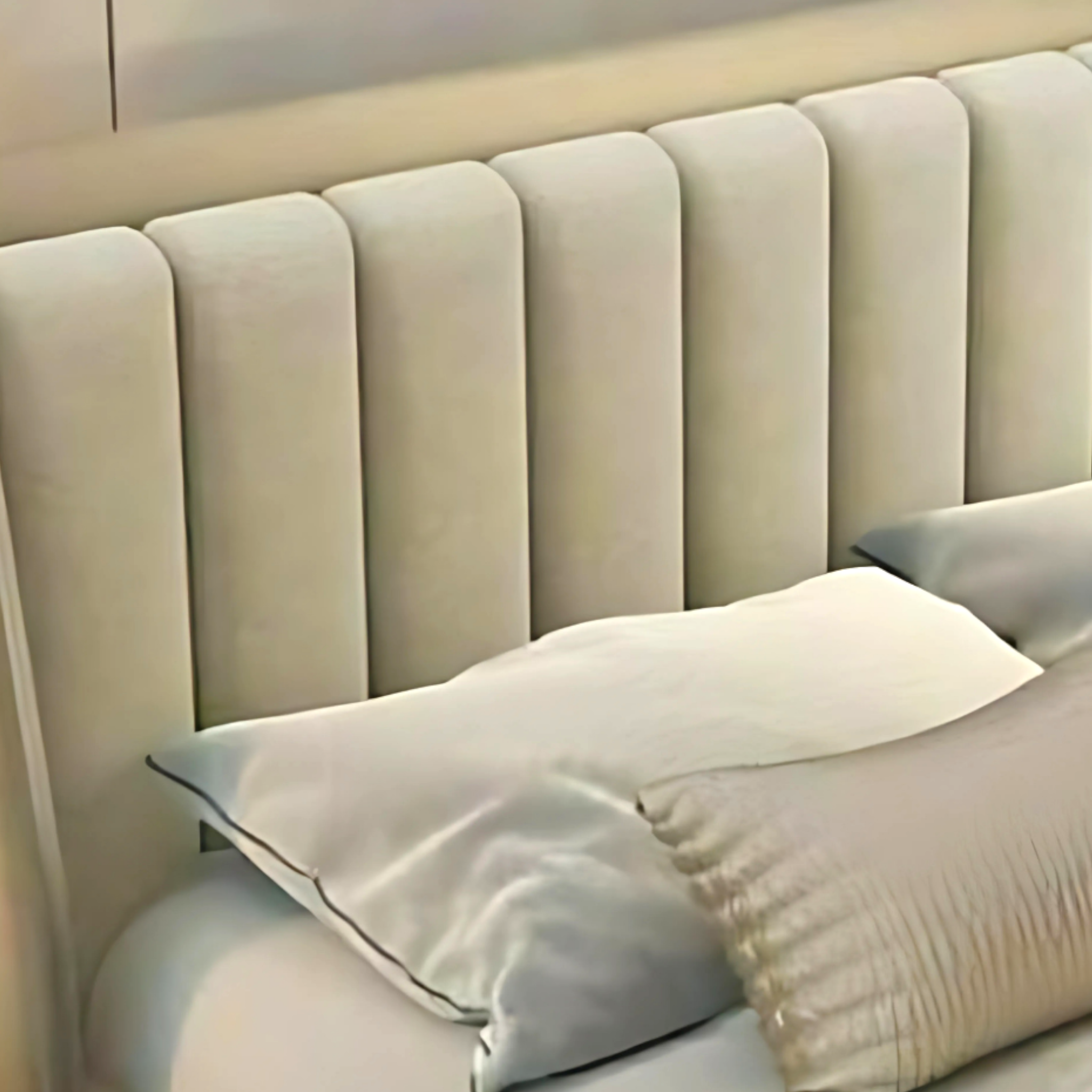 Beige upholstered headboard with pillows on a bed