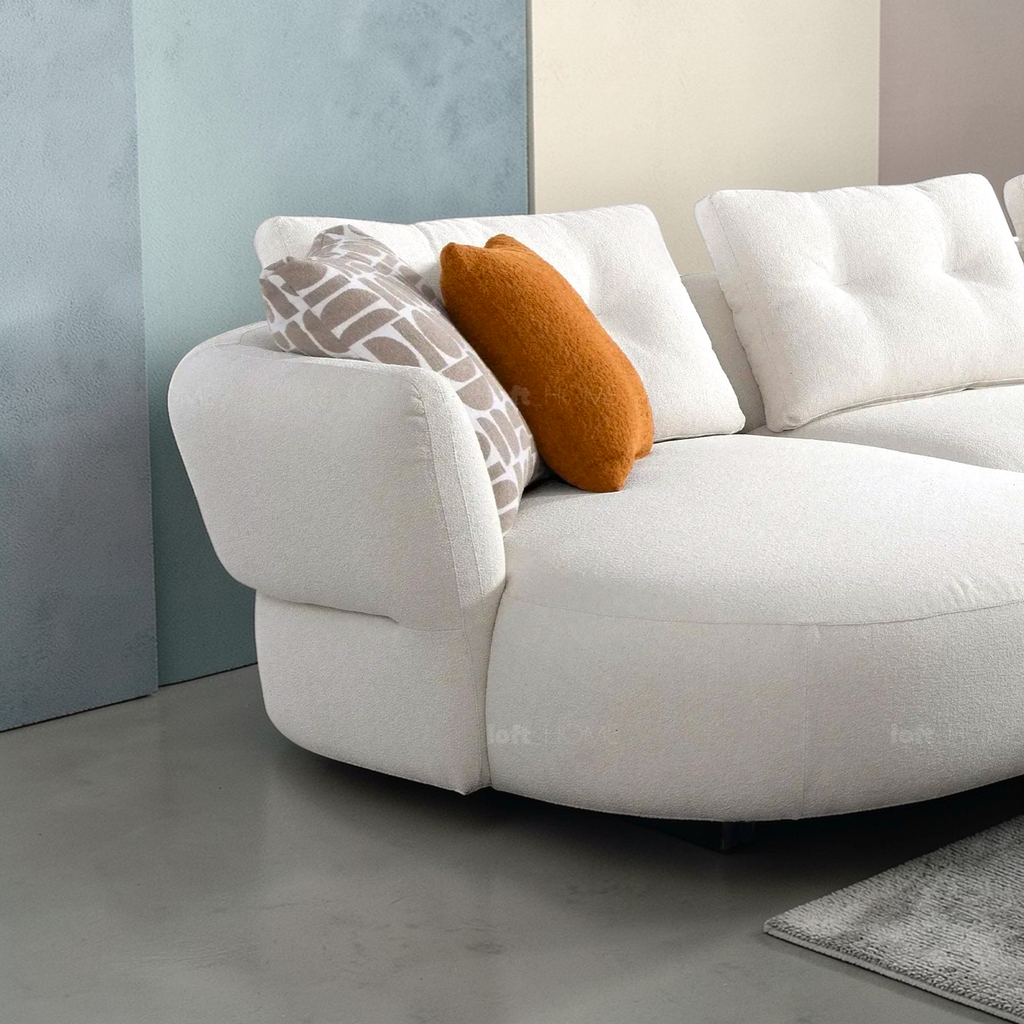 White sofa with colorful cushions against a neutral wall.