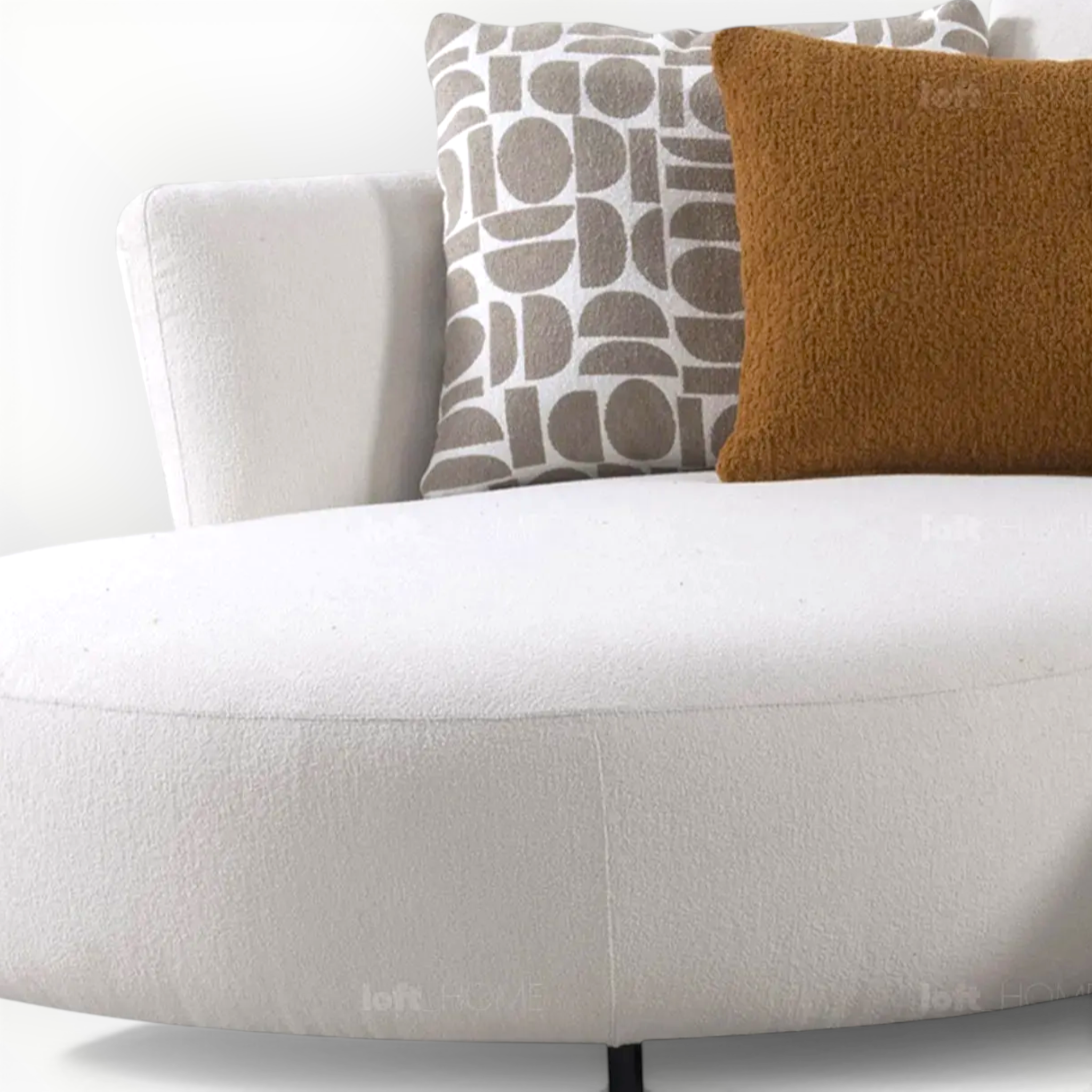 White sofa with patterned and textured throw pillows on a neutral background