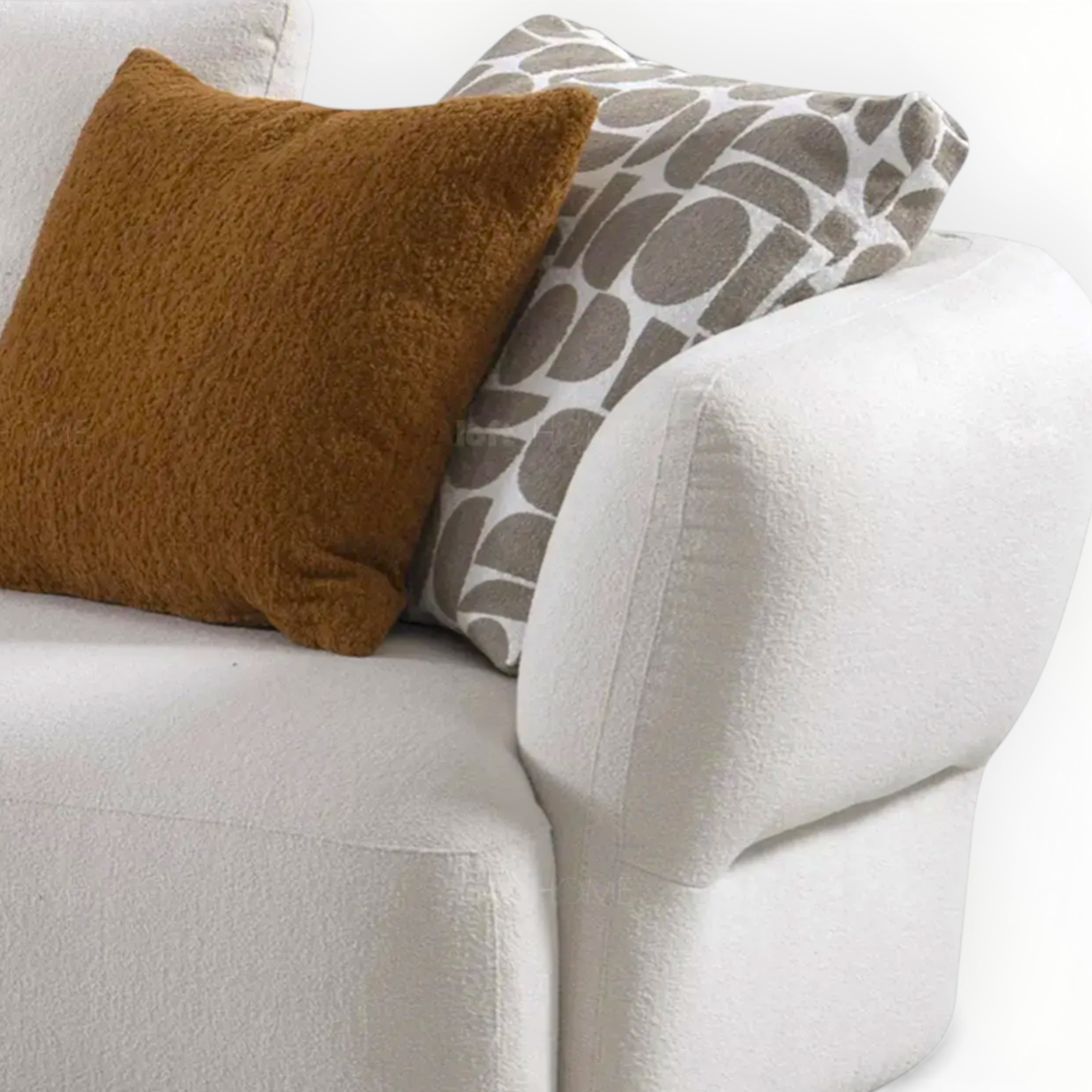 Two pillows, one brown and one with a pattern, on a white couch.