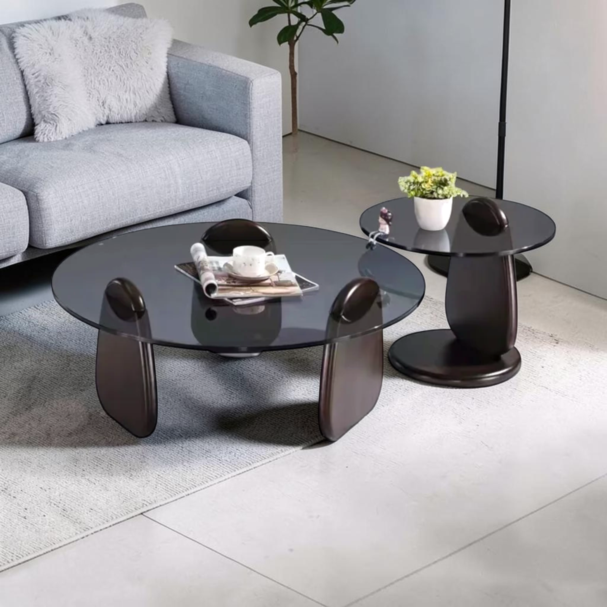 Modern living room with a gray sofa, glass coffee table, and side tables.
