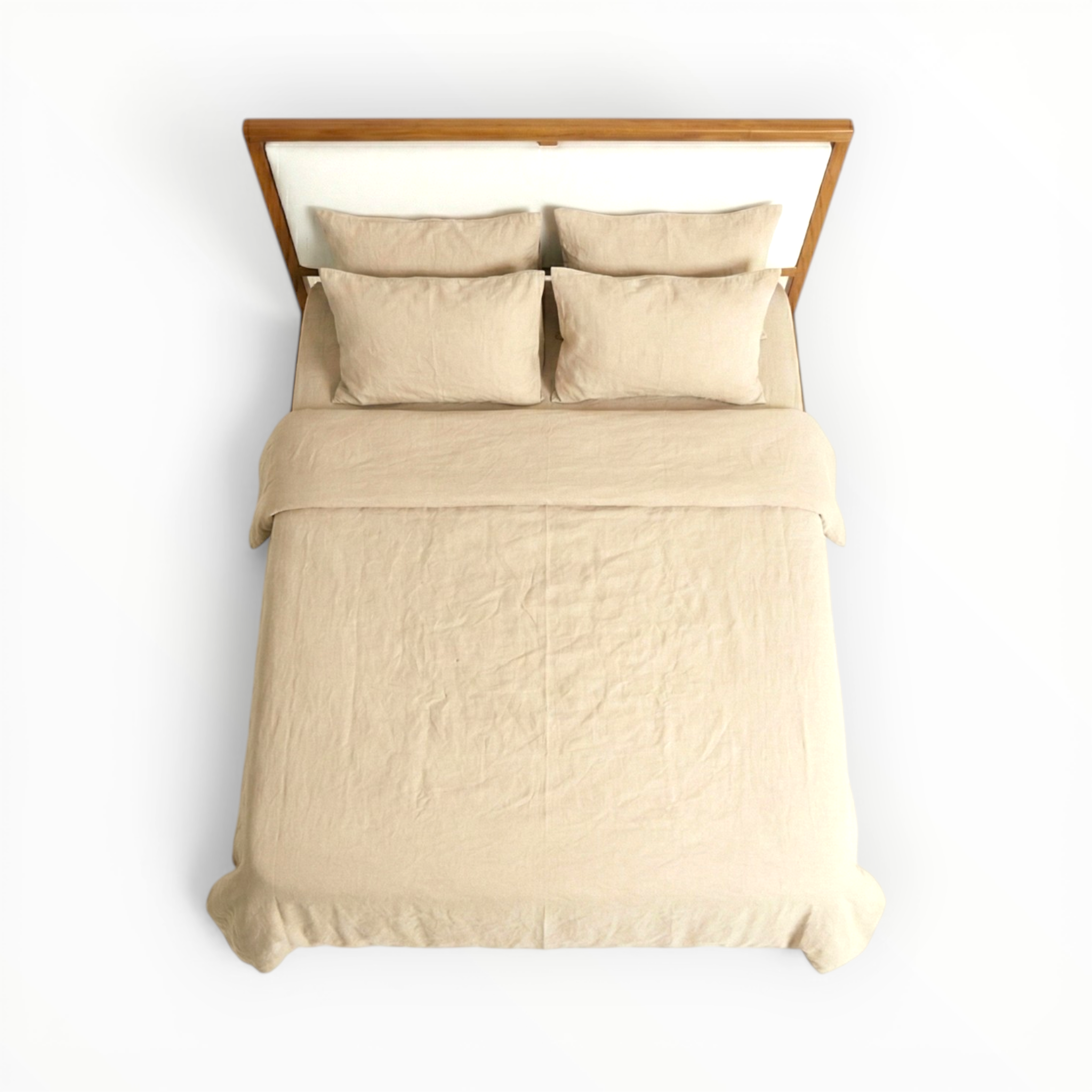 Beige bedding set with pillows on a bed against a white background