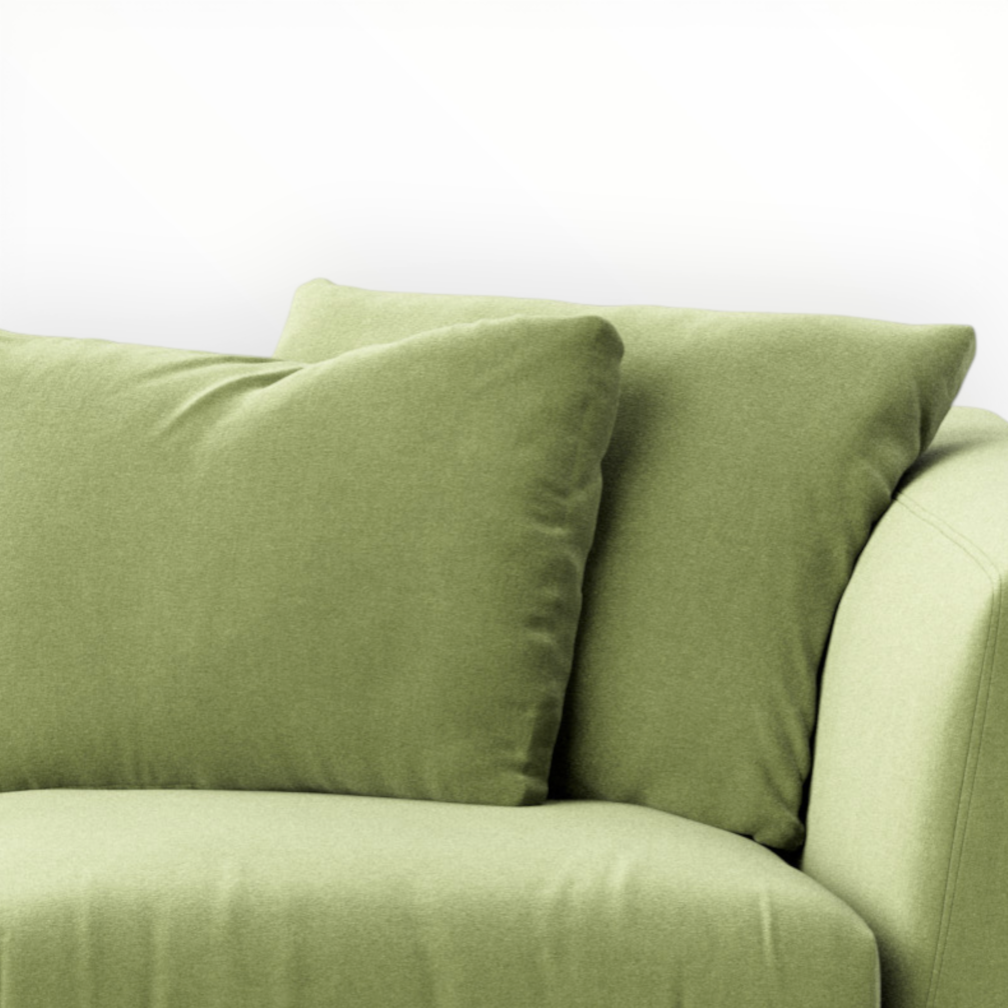 Green sofa with two matching pillows on a white background