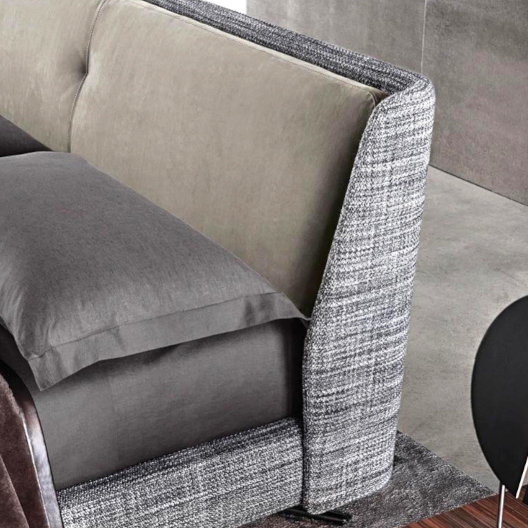 Gray and beige sofa with textured armrests in a modern interior setting.
