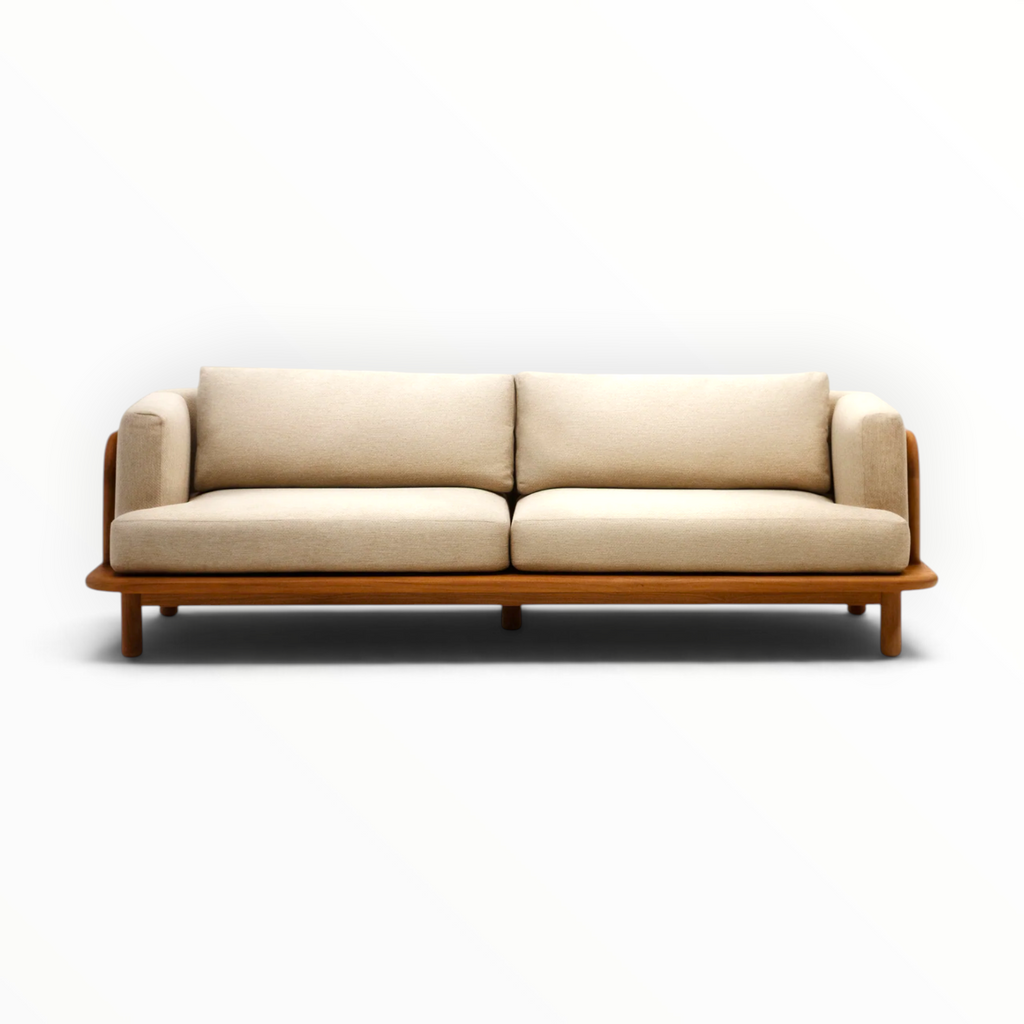 Arcadia teakwood sofa angled 3 quarter view showing rounded teak arm and floating platform base — Woodkraft Studio Hyderabad