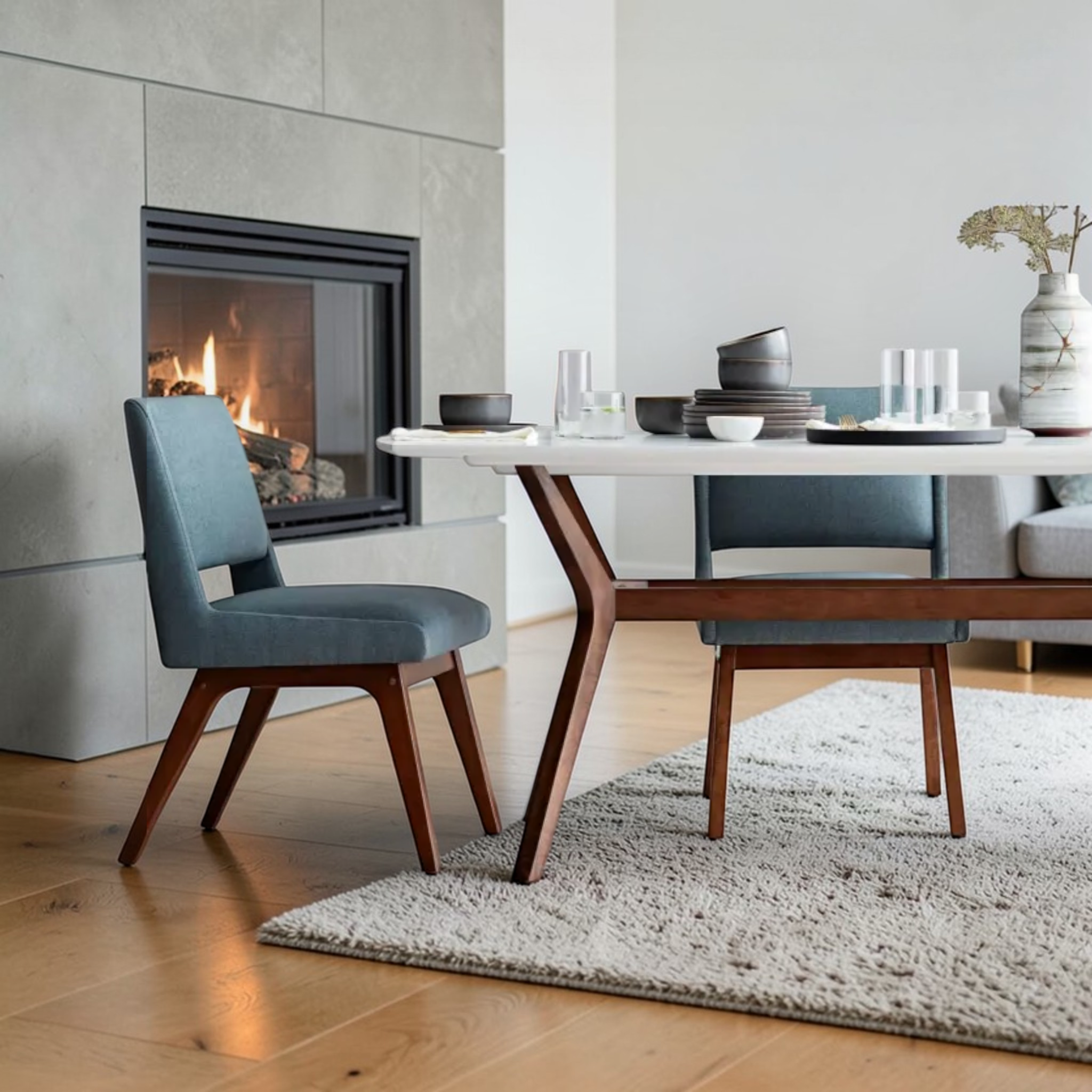 Modern dining room with a fireplace, table, and chairs.