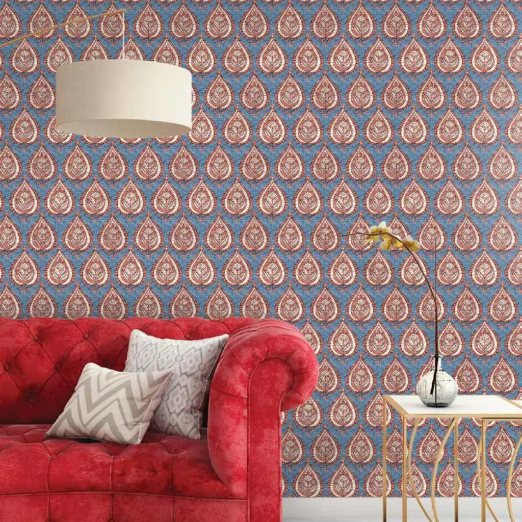 Living room with red sofa, patterned wallpaper, and side table.