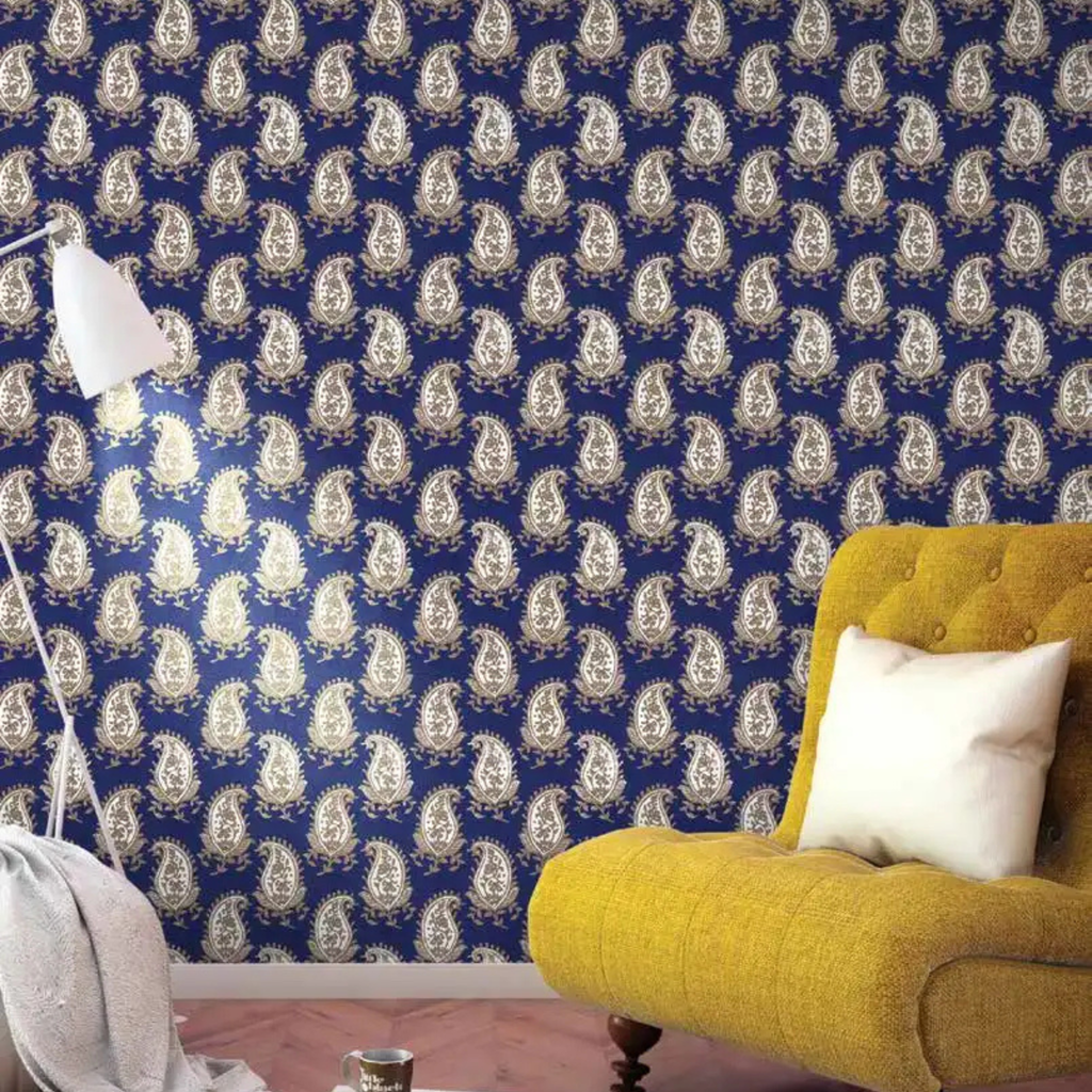 Yellow armchair against a blue wall with white paisley pattern