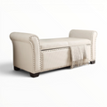 Beige storage bench with nailhead trim on a white background