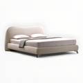 Beige bed with pillows and a blanket on a white background