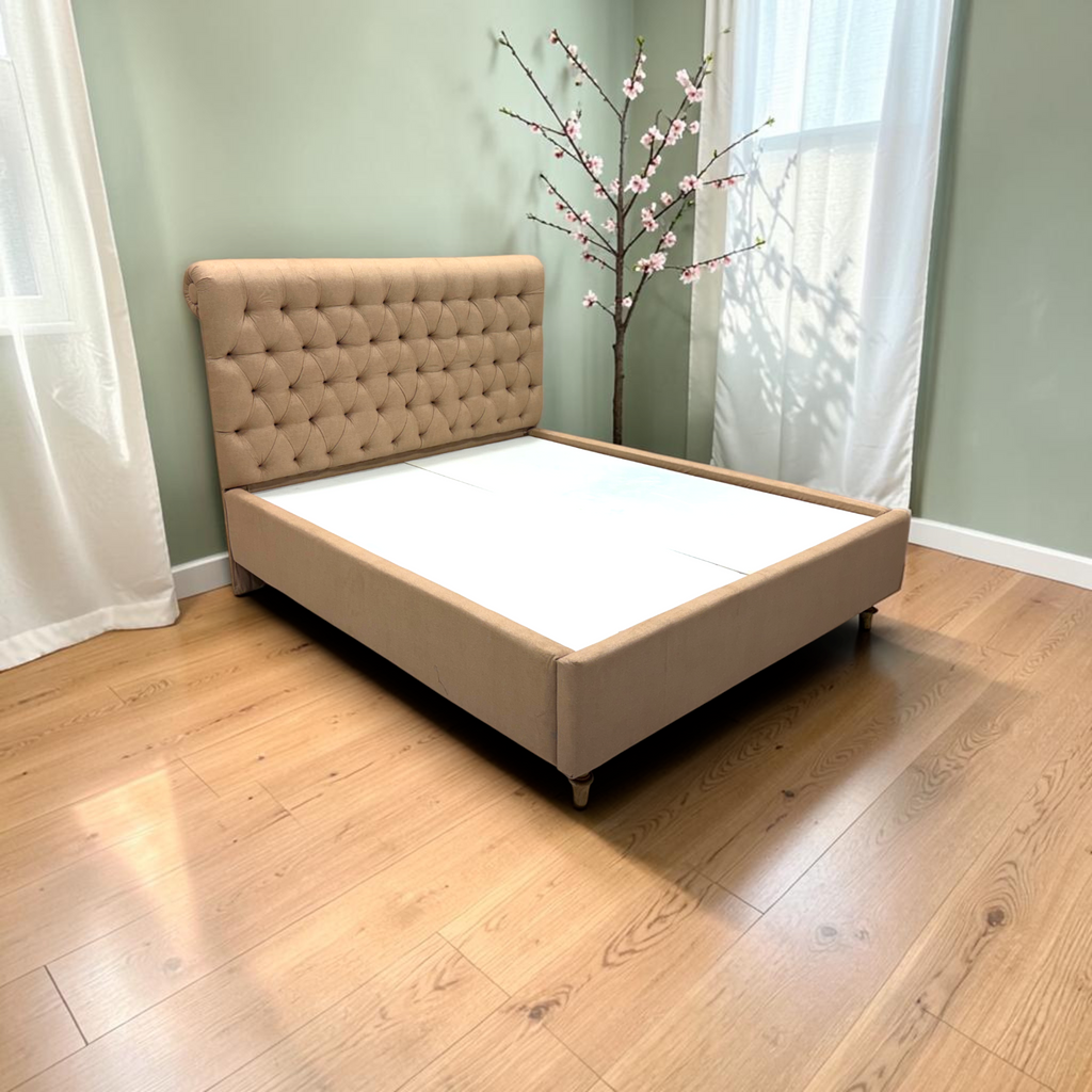 Side view of Cleo upholstered bed showing ornate turned legs and beige fabric, 5x6 ft queen size bed Hyderabad