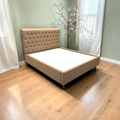 Side view of Cleo upholstered bed showing ornate turned legs and beige fabric, 5x6 ft queen size bed Hyderabad