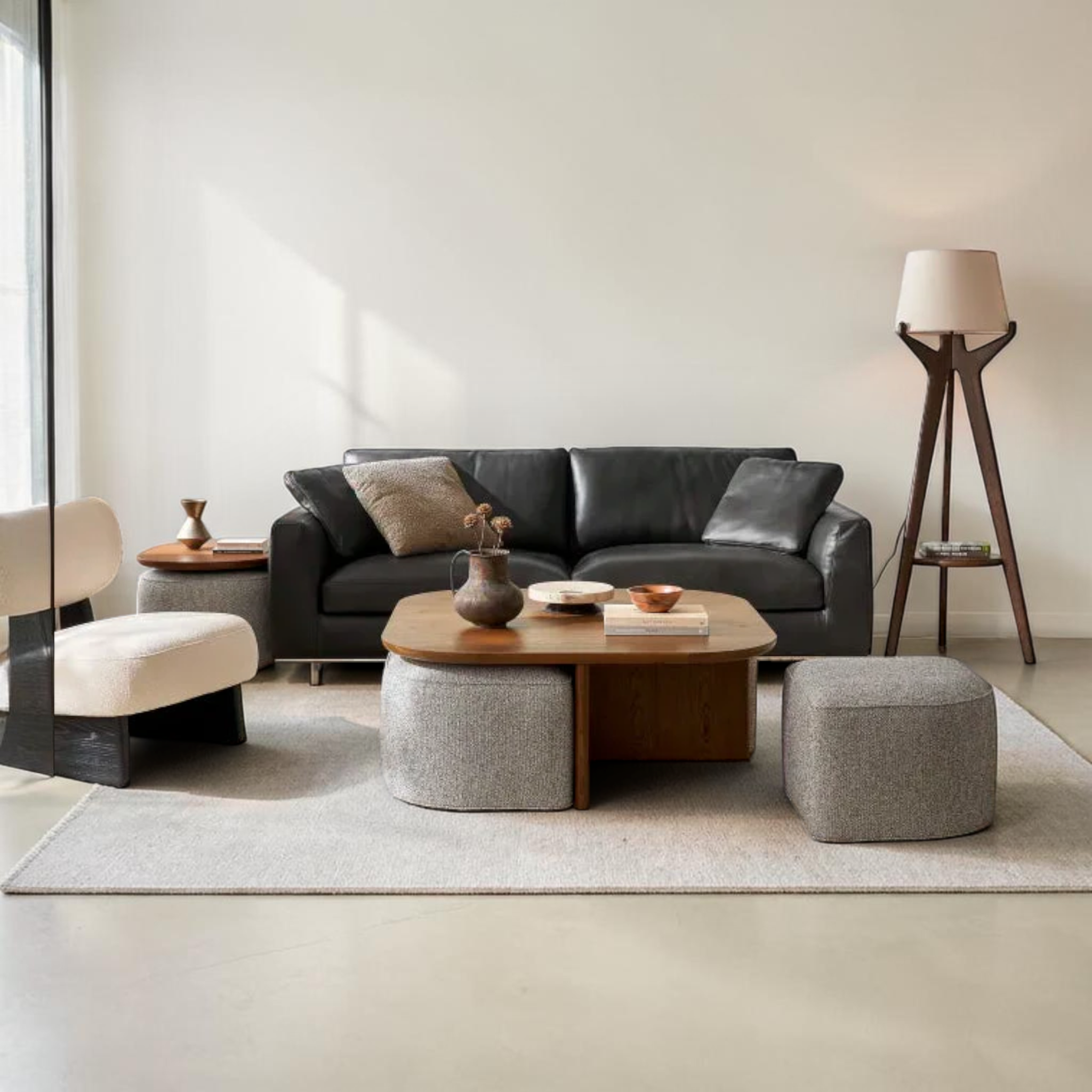 Modern living room with a black leather sofa, wooden coffee table, and decorative items.