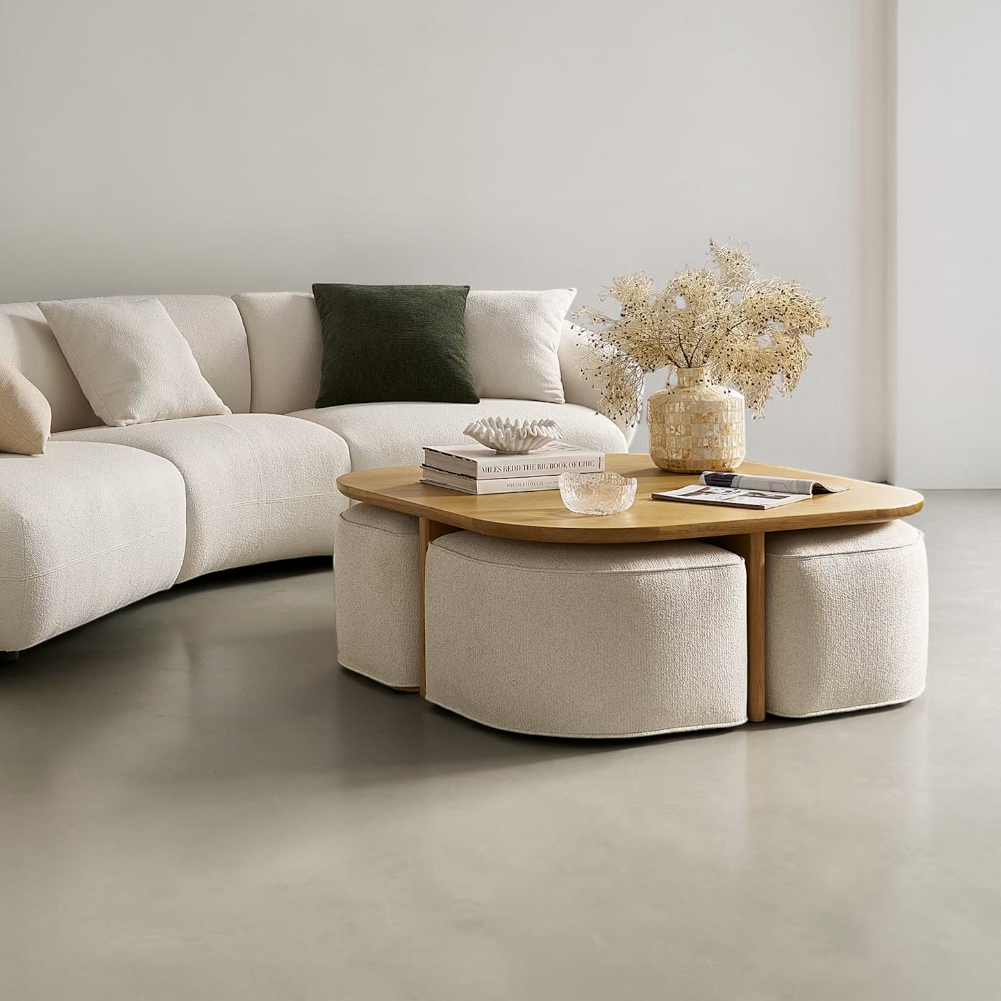 Modern living room with a sectional sofa, coffee table, and ottomans.