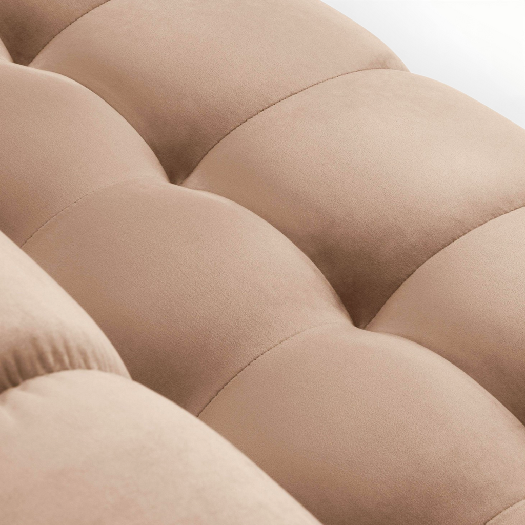 Close-up of a beige upholstered headboard with tufted design.