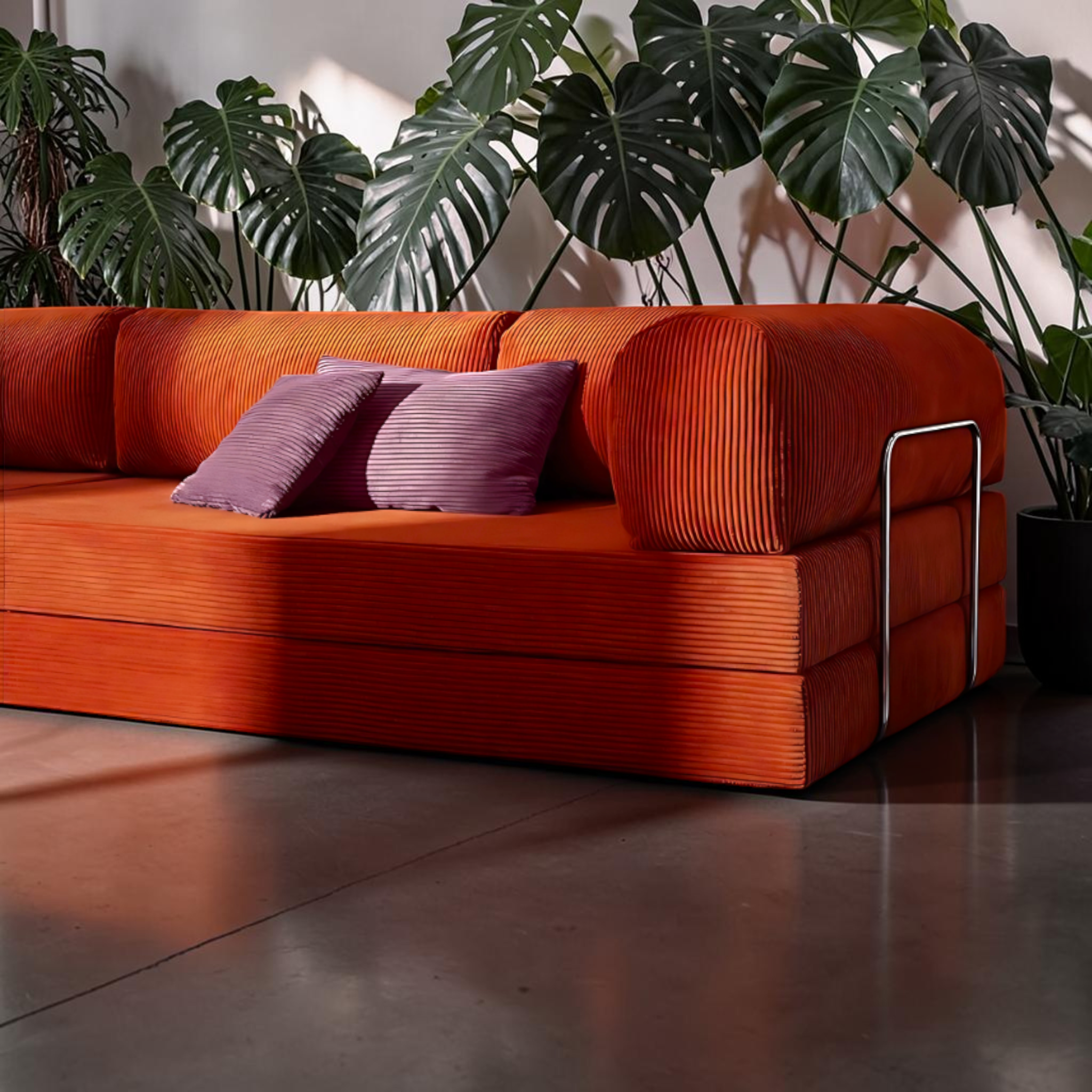 Orange sofa with purple cushions in a room with plants