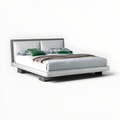 Modern bed with gray upholstered headboard and white bedding on a white background