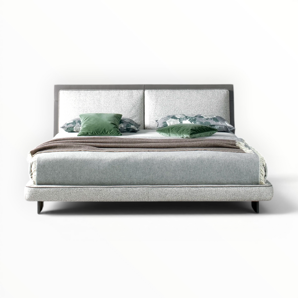 Gray upholstered bed with green and gray bedding on a white background