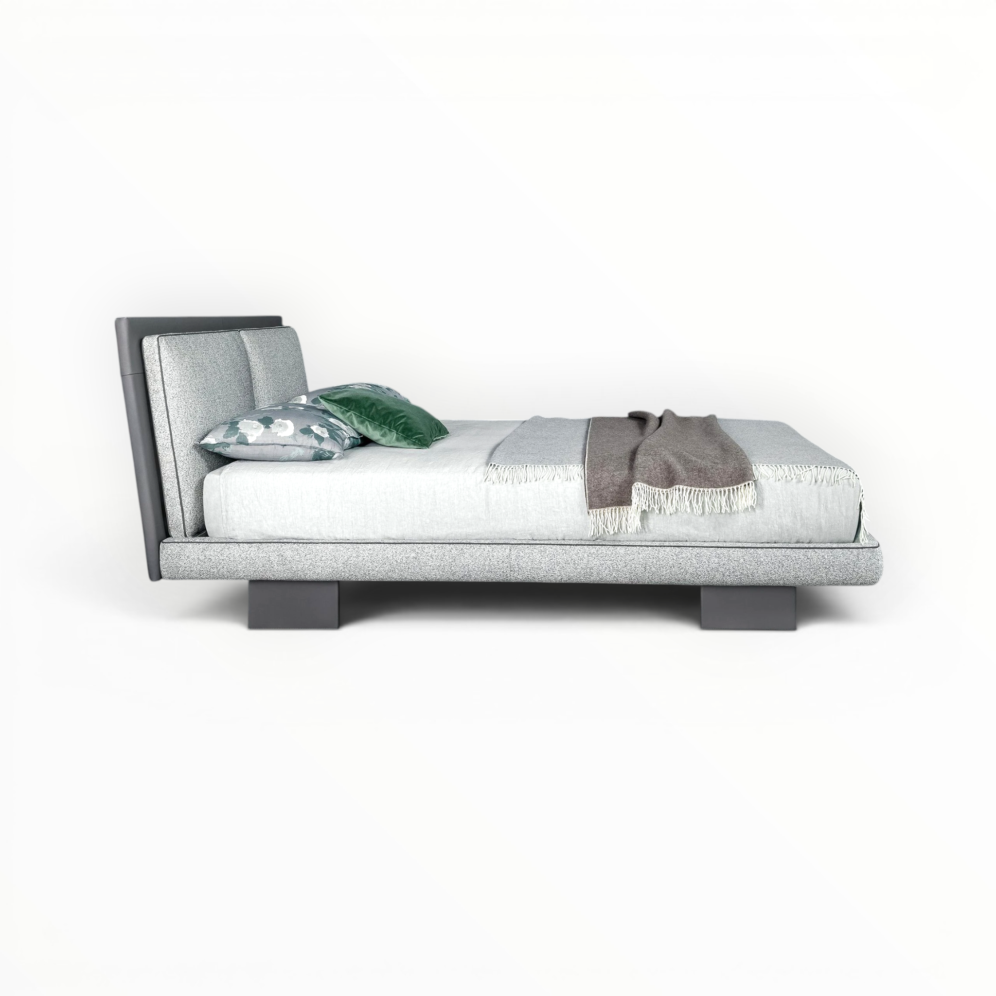 Modern bed with gray upholstered headboard and white bedding on a white background