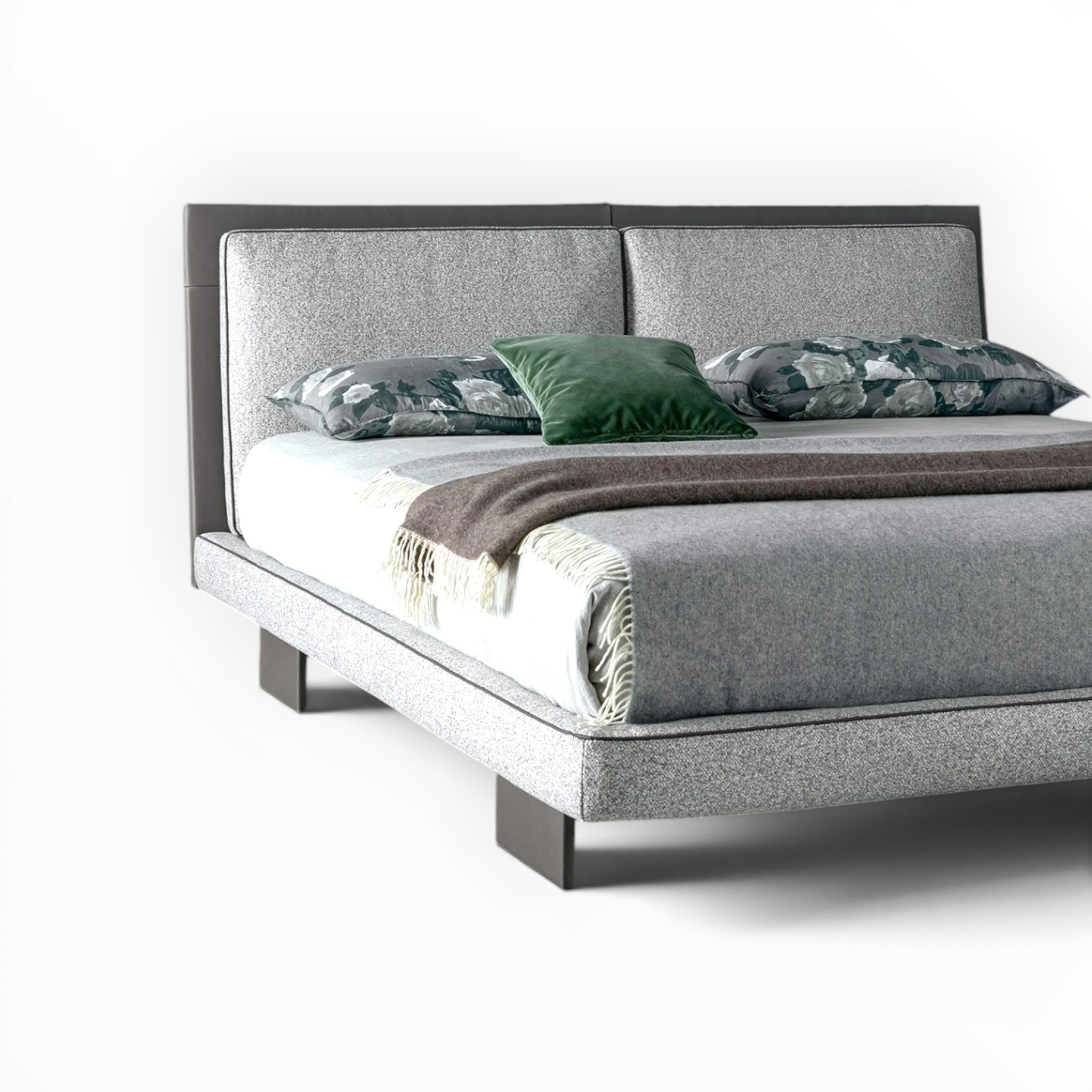 Gray upholstered bed with decorative pillows on a white background