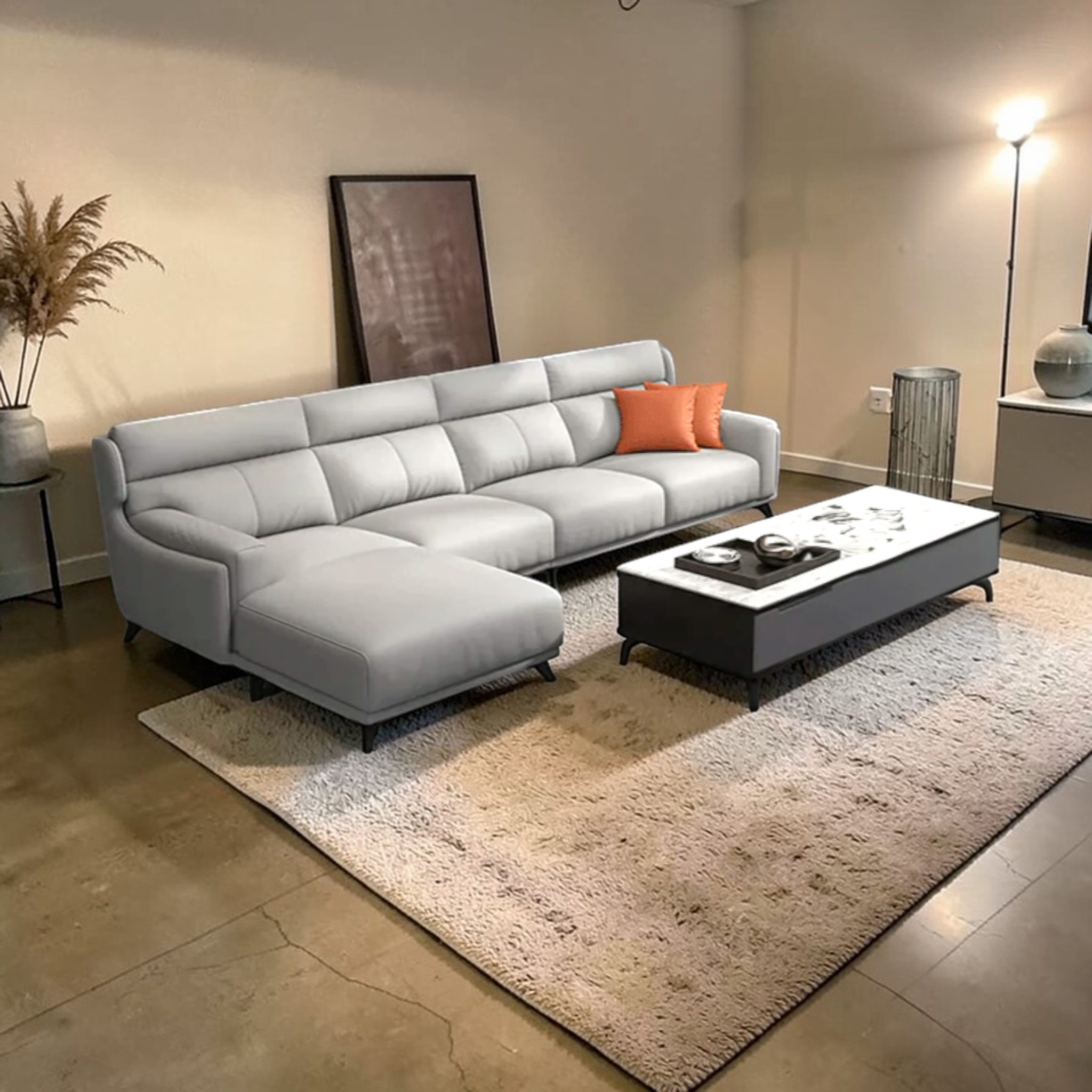 Modern living room with a gray sectional sofa, white coffee table, and decorative elements.