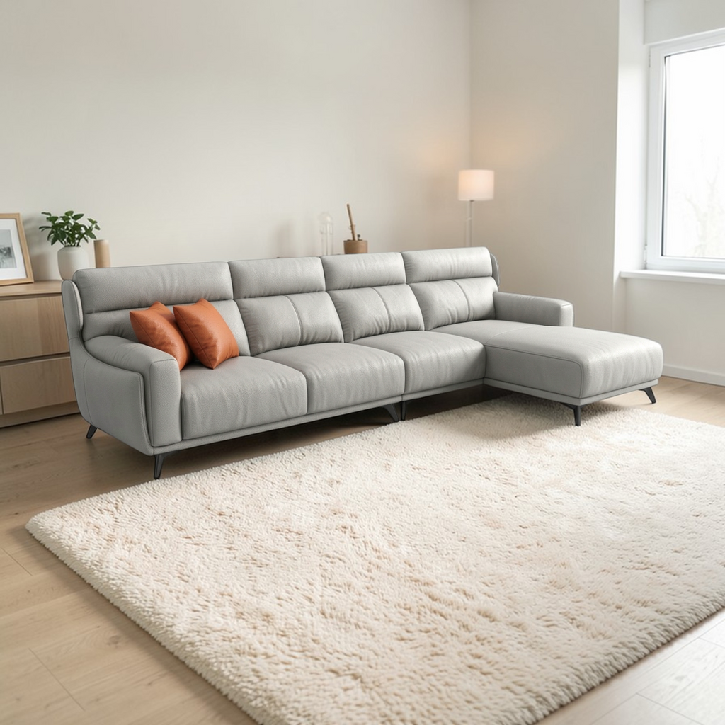 Gray sectional sofa in a living room with a beige rug and light-colored walls.