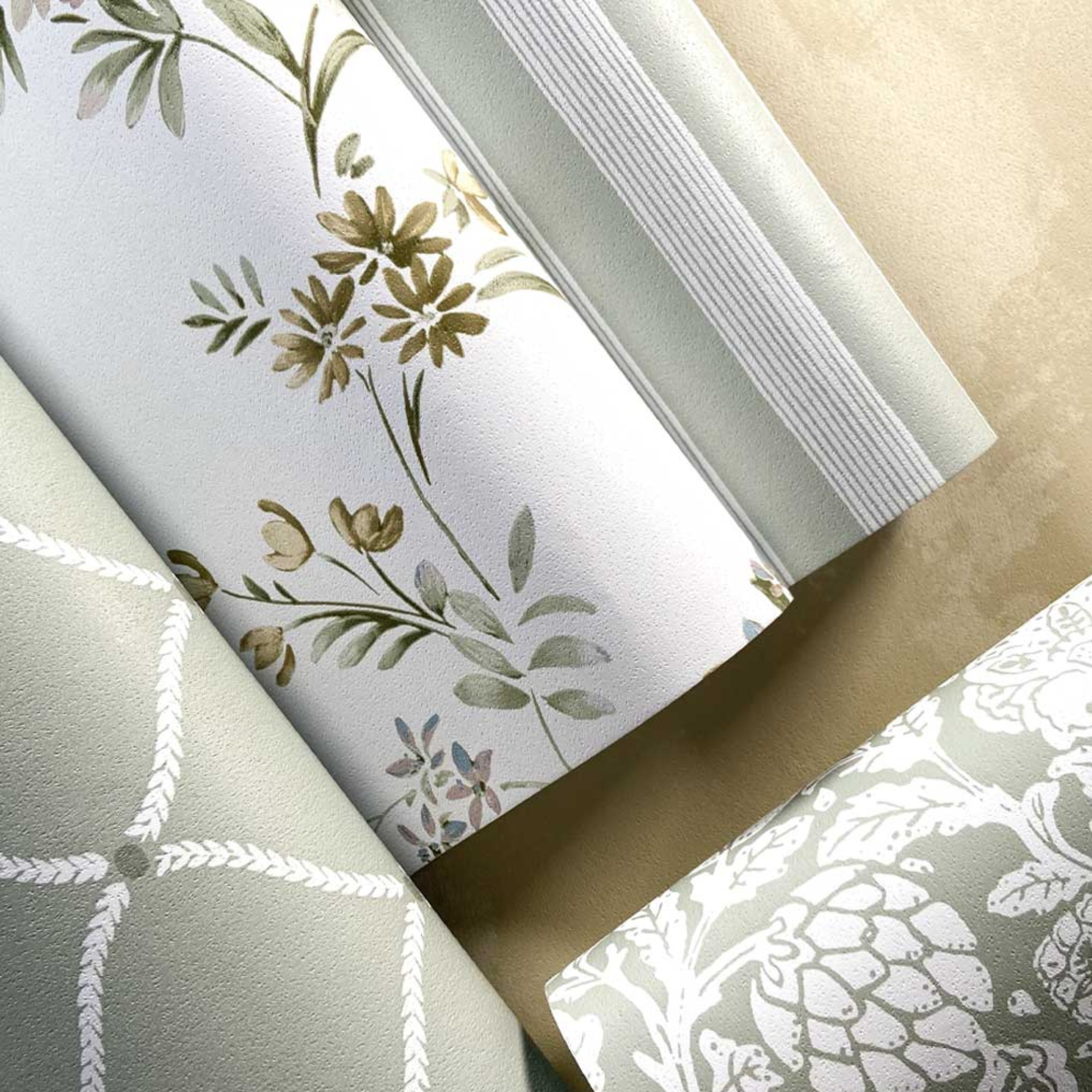 Three rolls of fabric with different patterns on a neutral background