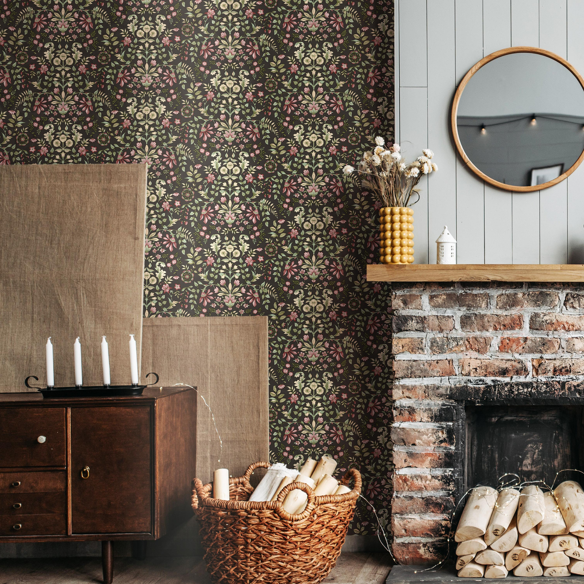 Room interior with floral wallpaper, wooden dresser, basket with logs, and round mirror.