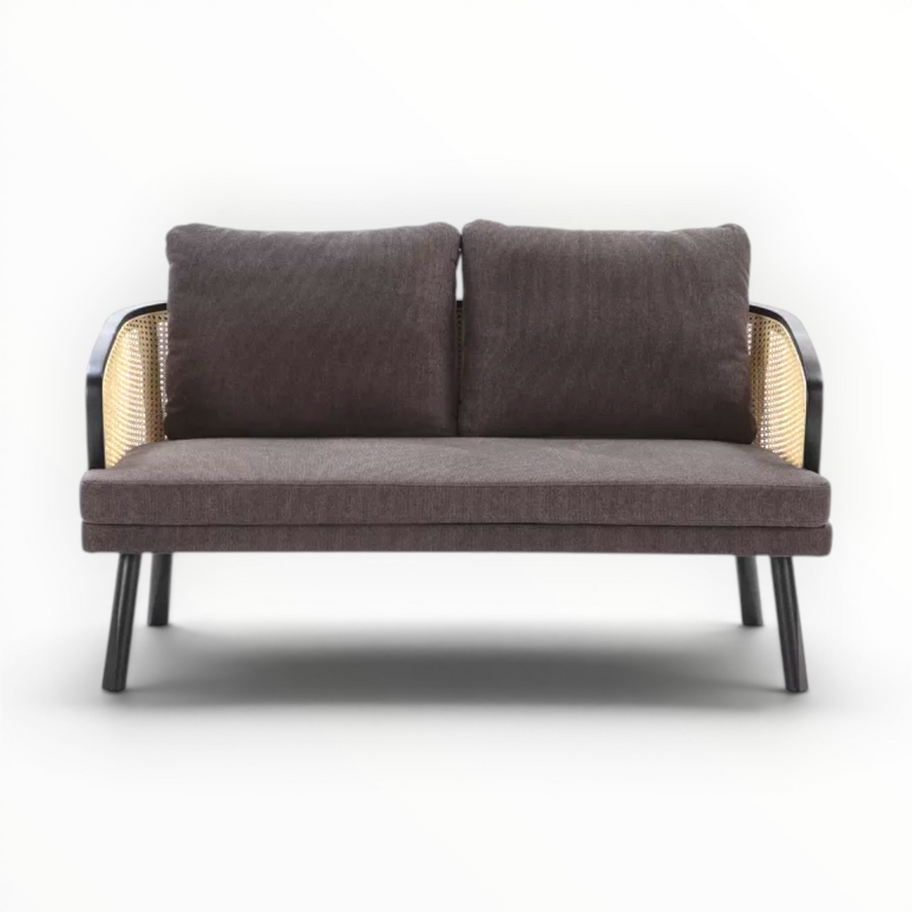 Brown sofa with wicker armrests on a white background