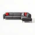 Gray sectional sofa with red and patterned cushions on a white background
