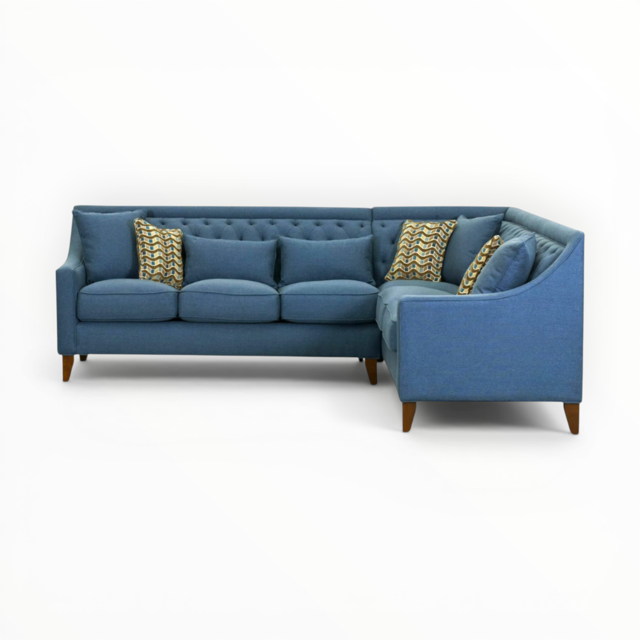 Blue sectional sofa with patterned cushions on a white background