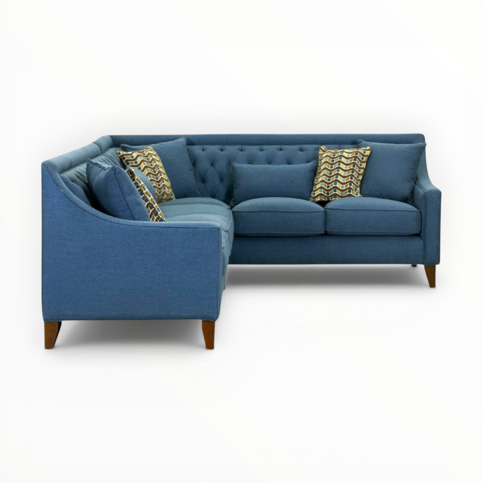 Blue sectional sofa with patterned cushions on a white background