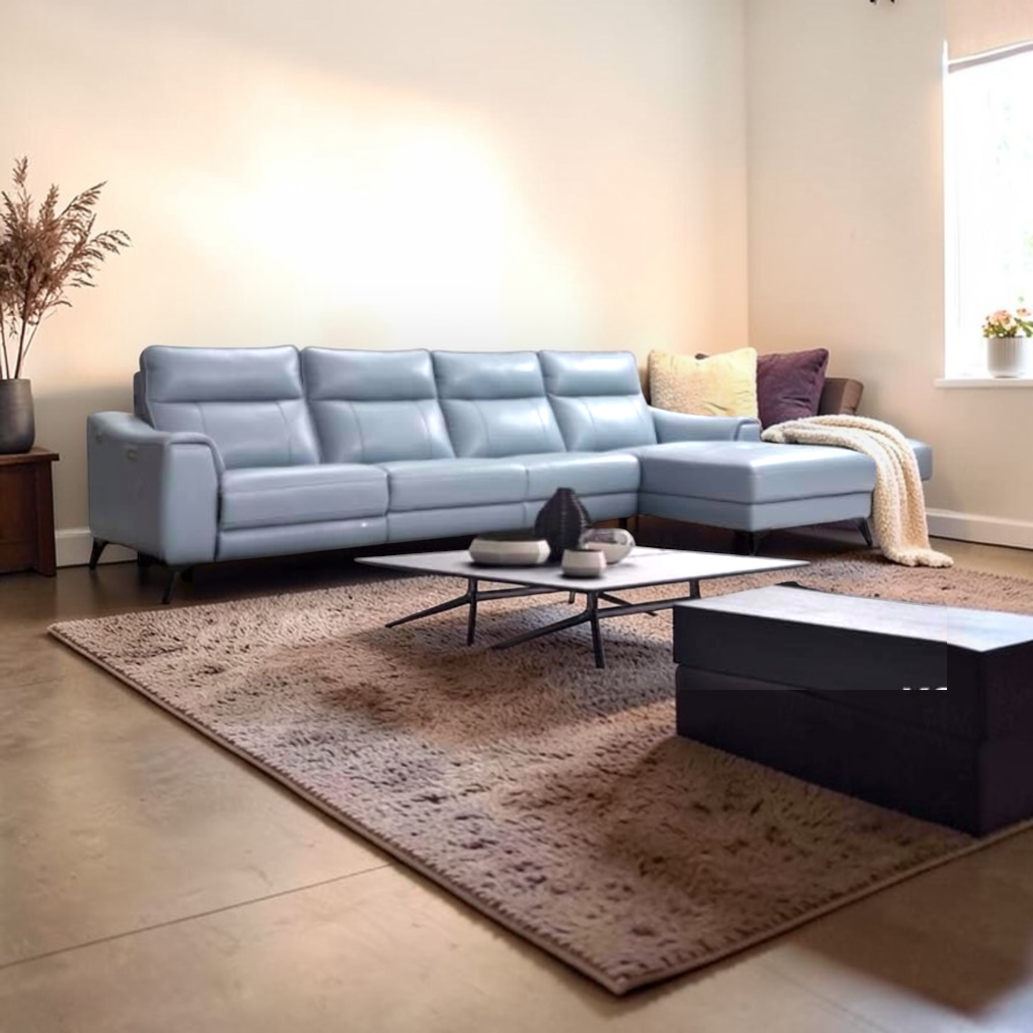 Modern living room with a light blue sectional sofa, coffee table, and decorative items.